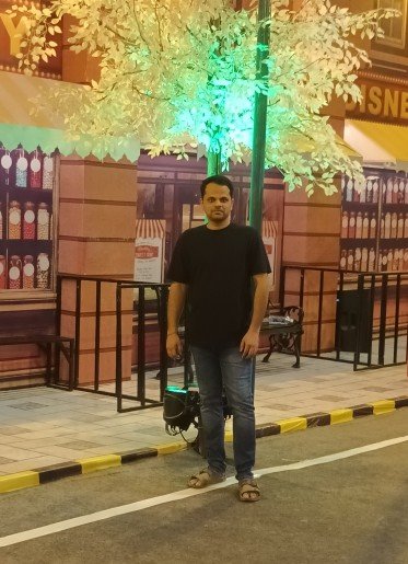 Kiran standing in front of a gate